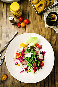 木桌子上的一盘牛肉蔬菜沙拉