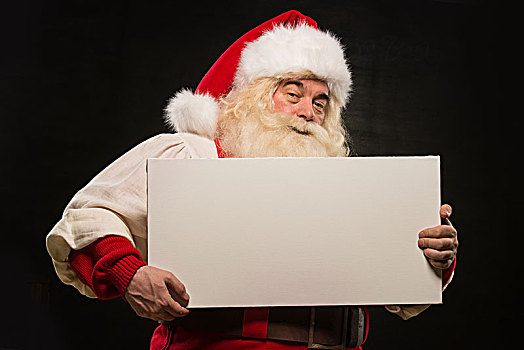 圣诞老人,拿着,白色,空白标志,有趣,微笑,站立,深色背景