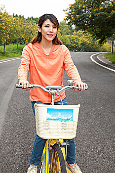 一个年轻女大学生在校园里骑车