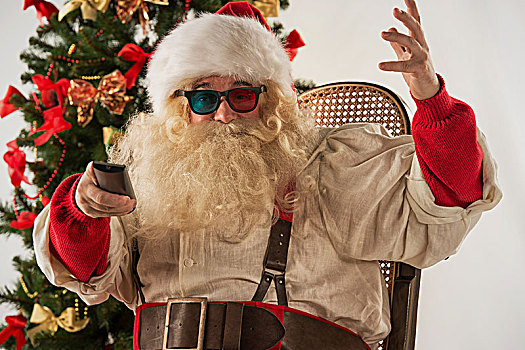 圣诞老人,坐,摇椅,靠近,圣诞树,在家,看电视,家庭影院,戴着,3d眼镜,拿着,遥控器