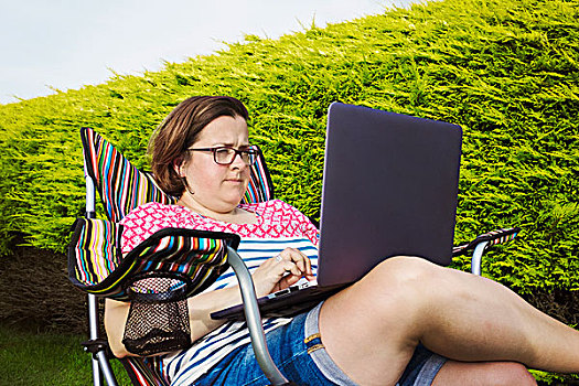 女人,坐,露营,椅子,斑点,树篱,笔记本电脑