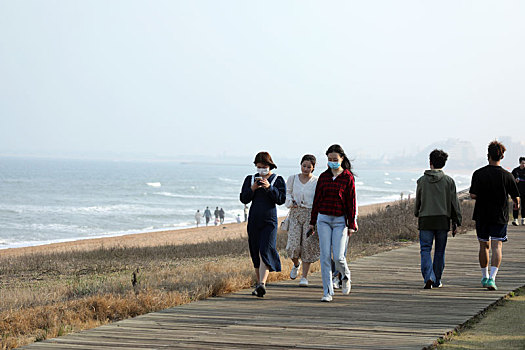 山东省日照市,面朝大海春暖花开,游客奔向海边休闲散步感受美好春天
