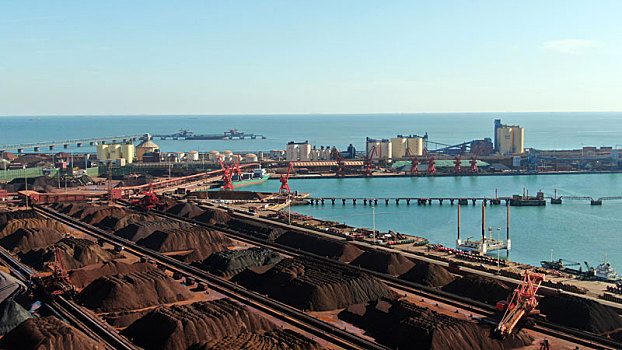 山东省日照市,航拍蓝天下的铁矿石堆场,繁忙有序蔚为壮观