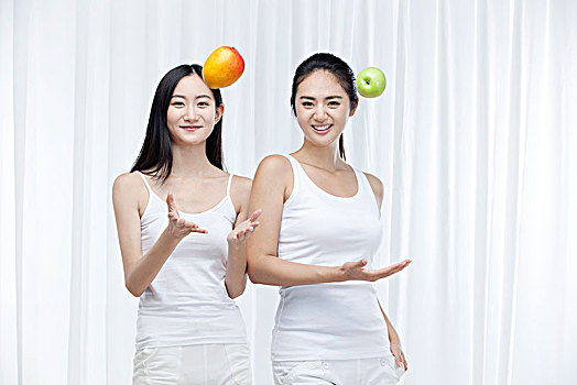 两个拿水果的亚洲女孩