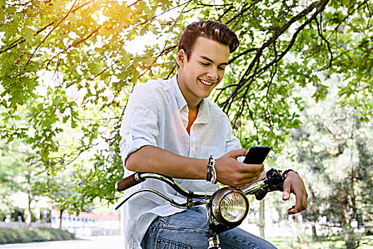 男青年,坐,马鞍,自行车,看,智能手机,微笑