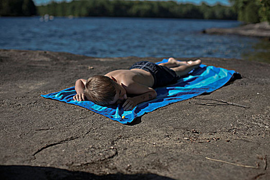 男孩,躺着,沙滩巾,岩石上,湖,安大略省,加拿大