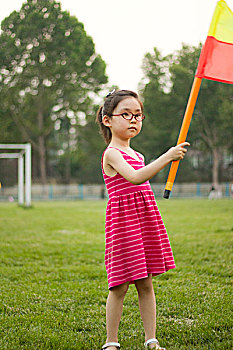 草地上举旗的小女孩