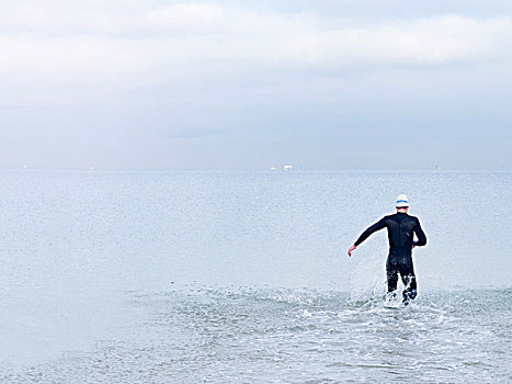 后视图,男人,紧身潜水衣,游泳帽,海洋,墨尔本,维多利亚,澳大利亚,大洋洲