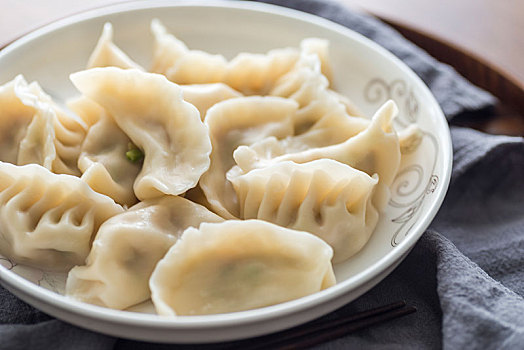 實木餐桌上煮熟的中華傳統美食餃子