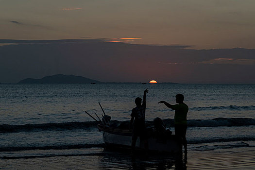 三亚亚龙湾海边日落人们的玩海水