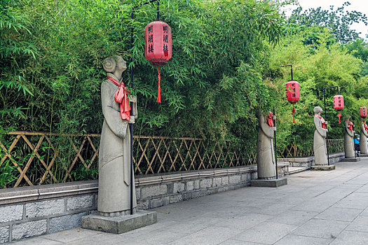 竹林前举着红灯笼的侍女石雕像,济南大明湖公园