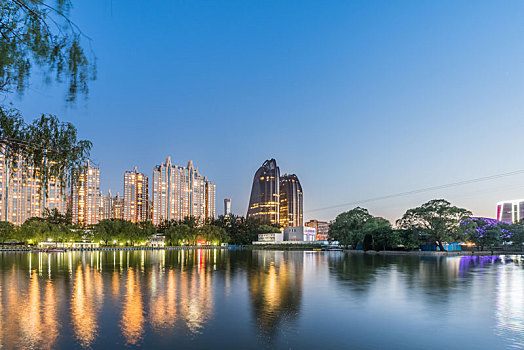 中国北京朝阳公园湖边的树林建筑夜景