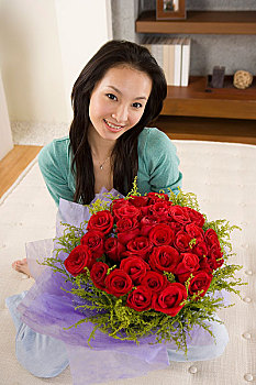 一个女人抱着一束鲜花坐在床上