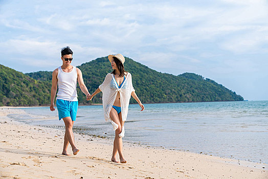 快乐的年轻情侣在海边散步