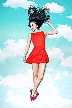 天空下穿红裙子的美女