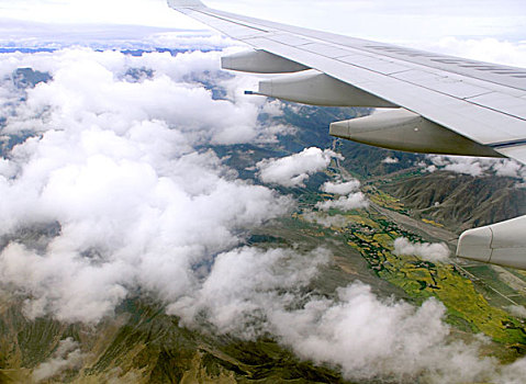 飞机机翼白色云层绿色山川