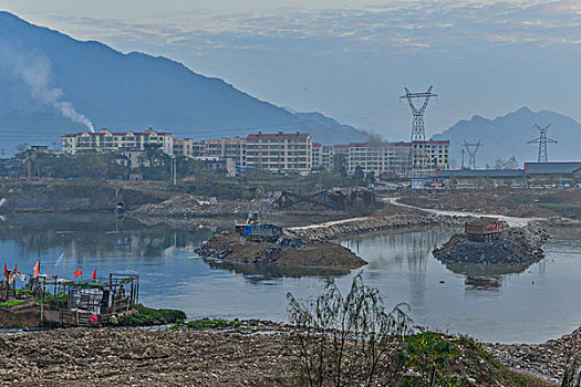 输电塔,房屋,炊烟,截流,拖拉机,汽车,推土机,池塘,河流,两岸,高压线,高压塔,电力,黄昏,清洁能源,绿色电力