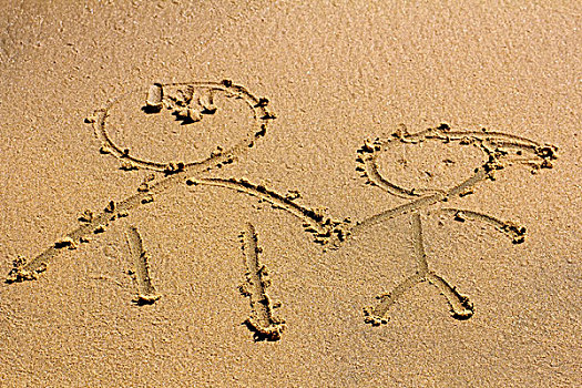 在海滩边黄色细腻海沙上画着两个友好的人类形象