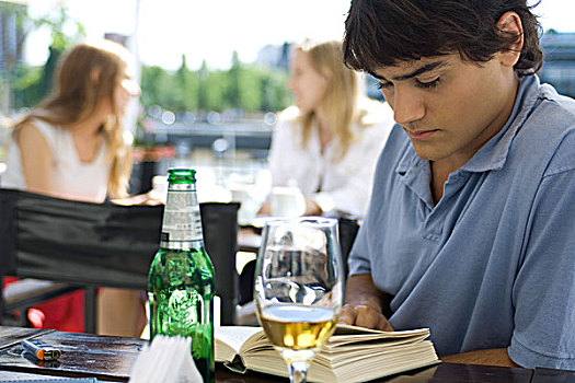 男青年,坐,露天咖啡馆,读,书本,啤酒
