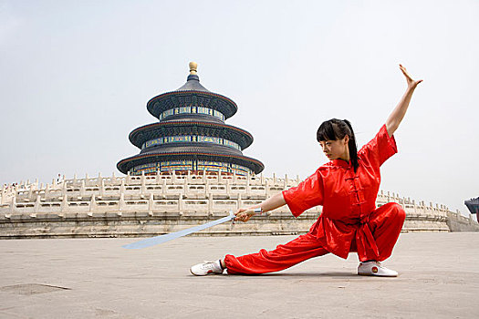 中国武术--一名女武术运动员在天坛祈年殿前练刀法