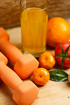 哑铃,橙汁,水果和干果放在木桌上