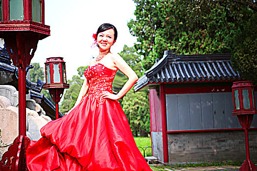 身着红色礼服的年轻女子站在古老的建筑之间