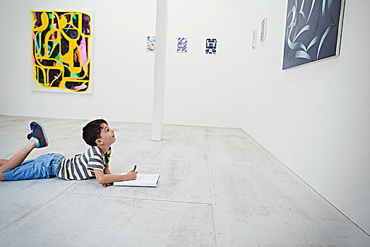 男孩,短小,黑发,躺着,地面,画廊,笔,纸,看,现代,绘画