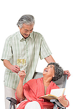快乐的老年夫妇坐在沙滩椅上
