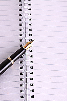 一个敞开的笔记本和一支钢笔