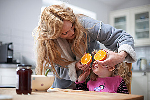 女孩,坐,厨房用桌,母亲,拿着,平分,橙色,正面,眼睛