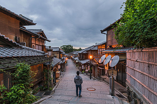一名男性走在清晨日本京都二年坂的复古街道上
