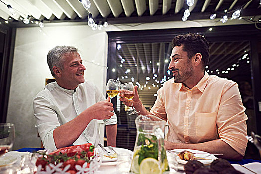 两个男人,坐,餐桌,拿着,葡萄酒杯,制作,干杯