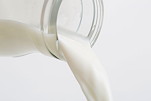 从瓶子里倒出的牛奶,牛奶的液体展现