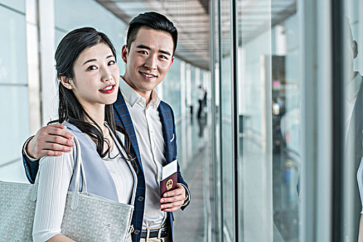 年轻情侣在机场拿着护照和机票