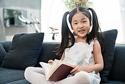 小女孩在沙发上看书