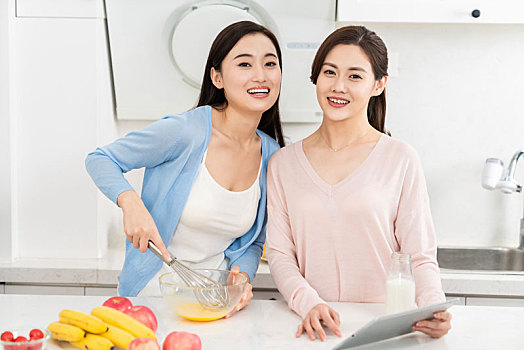 年轻女子在厨房边做饭边和朋友聊天