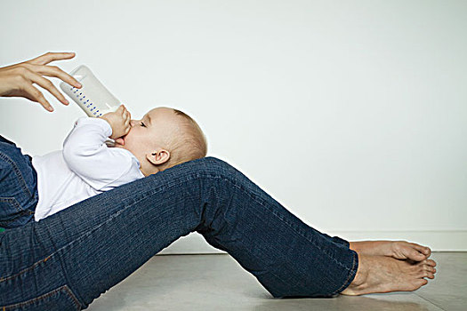 婴儿,躺着,腿,用瓶子喝,侧面视角