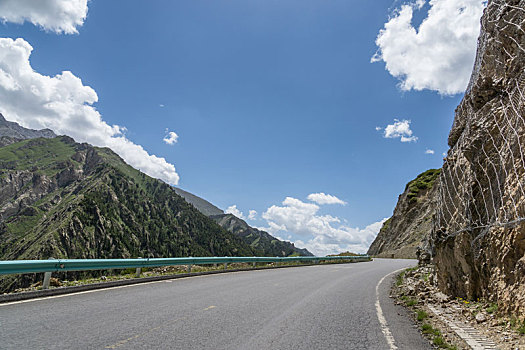 中国新疆夏季蓝天白云下高山森林g217独库公路弯道