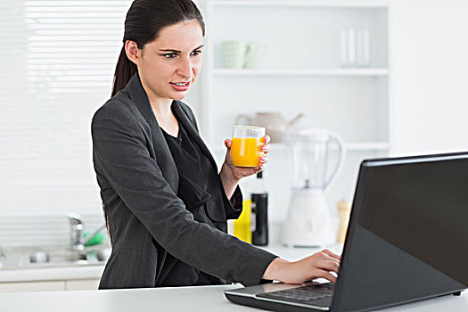 女人,看,笔记本电脑,拿着,果汁杯,厨房
