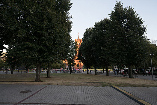 德国柏林亚历山大广场从树林里远眺黄昏阳光下的市政厅