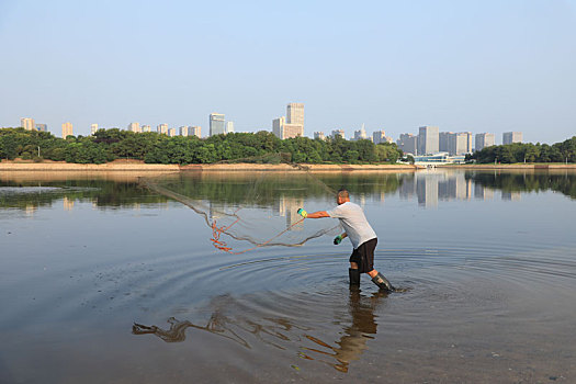 山東省日照市,清晨的瀉湖生機勃勃,市民悠閑垂釣撒網捕魚樂享生活