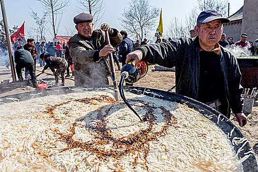 豫北农村厨师为大锅饭添加酱油调味品