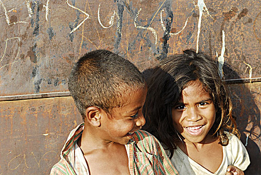 portrait,of,boy,with,white,teeth,and,dark,skin,an,open,shirt,other,in,blurred,background