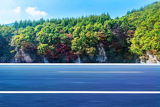 秋季蓝天山脚下的高速公路