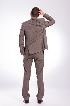 背影,年轻,商务,男人,挠,头部,全身,背面视角,拿着,牵手,灰色背景