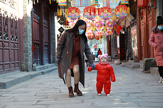 2022年2月6日,山东淄博市民纷纷来到周村古城,和家人乐享假日生活,欢度新春佳节,萌娃和宝妈一起走在青石板上,享受难得的亲子时光