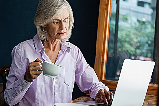 老年,女人,喝咖啡,工作,笔记本电脑,桌子,咖啡,店