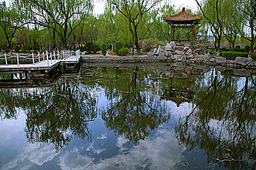 中国古典园林湖泊中的石板桥和凉亭