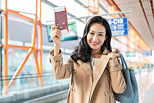 年轻女子在机场展示护照和机票