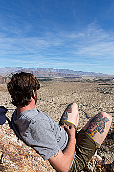 男青年,岩石上,向外看,风景,安萨玻里哥沙漠州立公园,加利福尼亚,美国